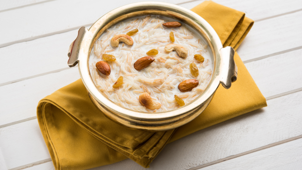 A traditional brass bowl filled with creamy Semiya Mix garnished with almonds, cashews, and raisins, placed on a mustard yellow napkin.